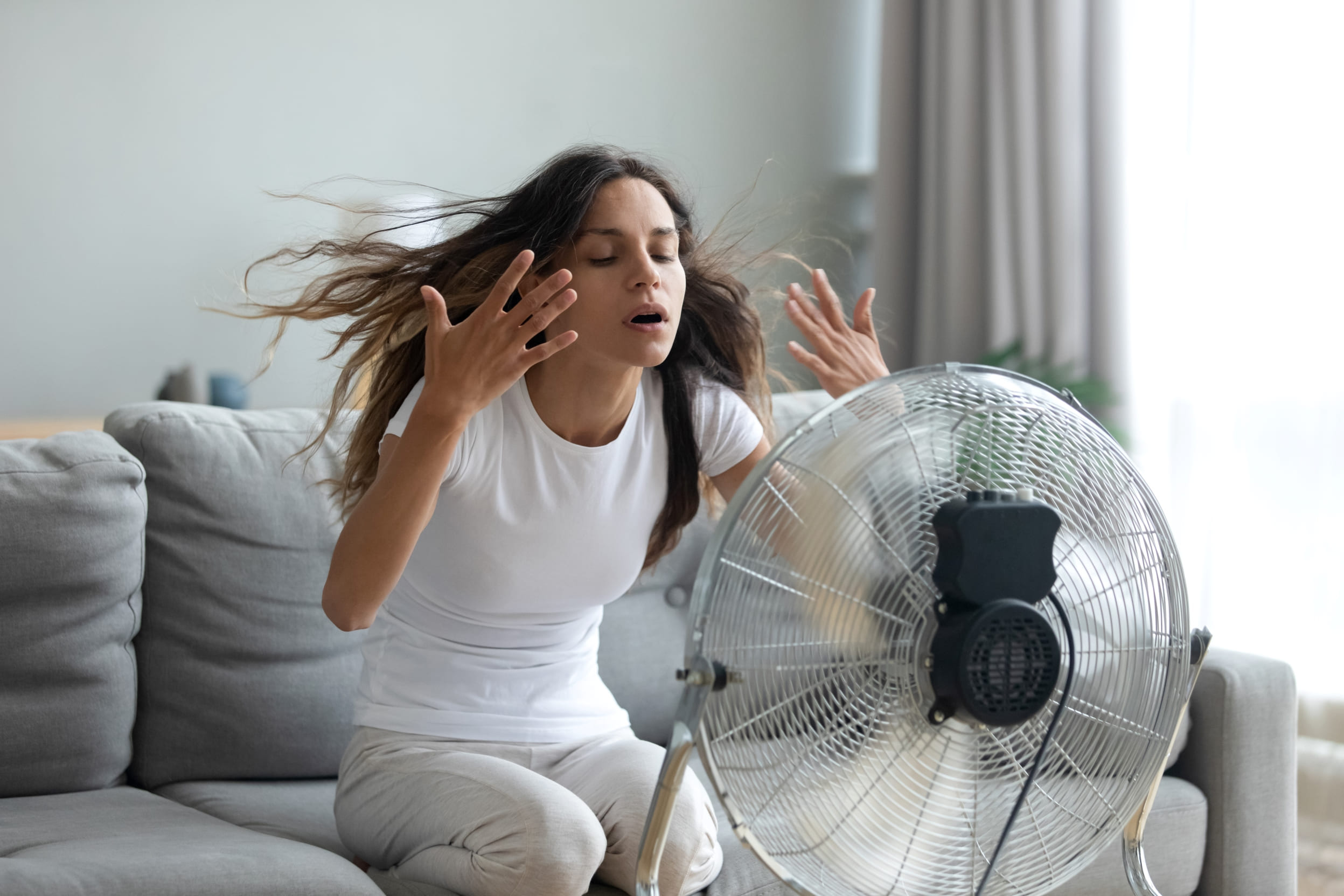 Mujer dándose aire con un ventilador