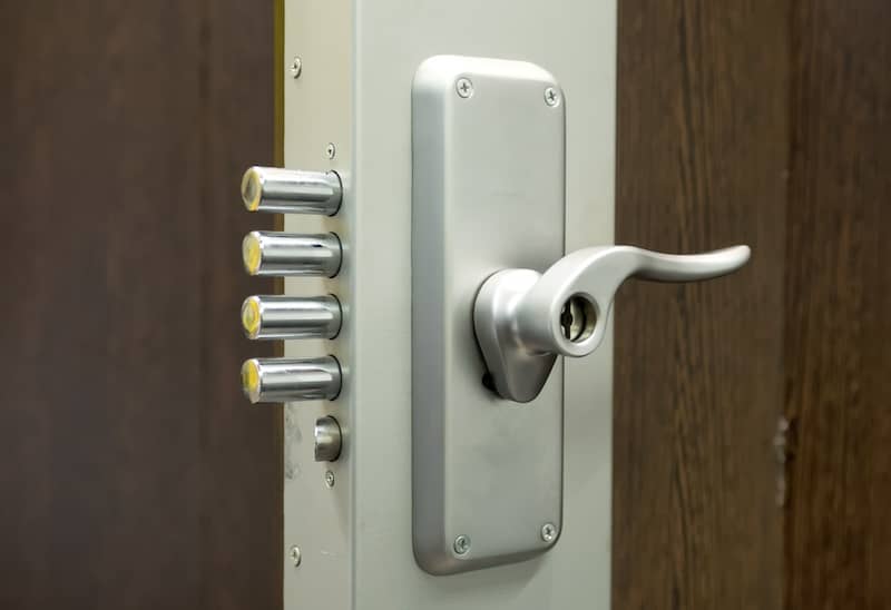 Cilindro de alta seguridad instalado en una puerta con escudo de protección.
