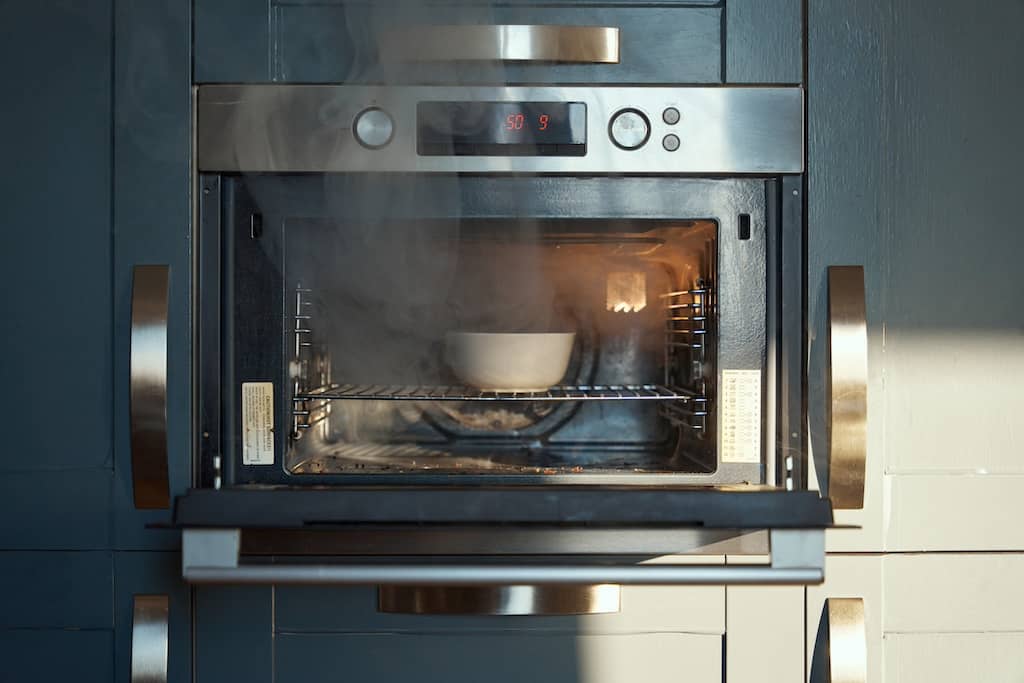 Horno moderno en una cocina elegante con iluminación natural.