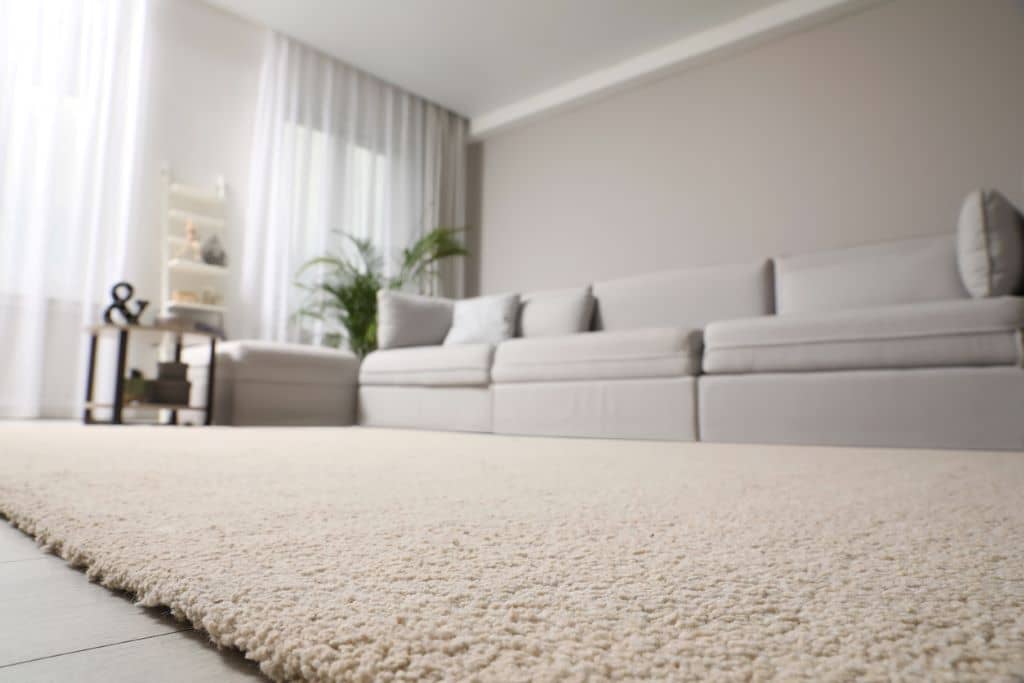 Moqueta de color claro en una sala de estar moderna, ayudando a mejorar la calidad del aire interior y aportando calidez al ambiente. 