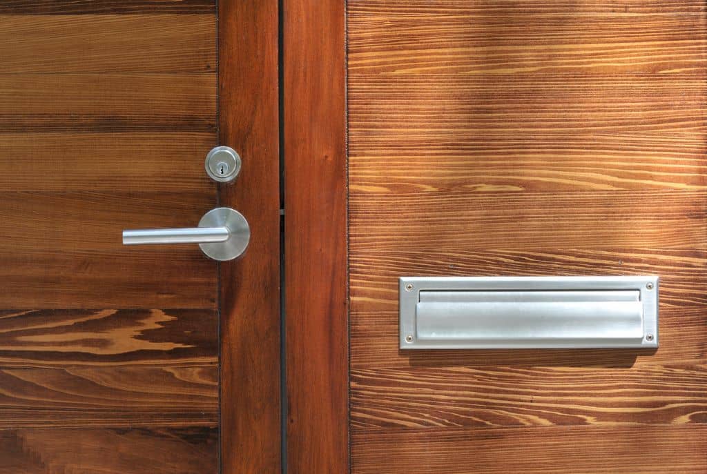 Manilla de puerta moderna instalada en una puerta de madera, destacando su diseño elegante y funcionalidad. 