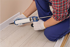 Profesional sellando con silicona un rodapie